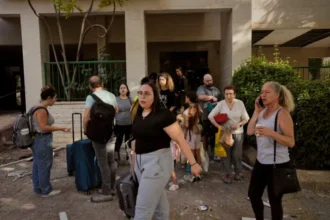 People evacuating a building next to a site stuck by an Iranian missile strike in Beersheba, Israel, on Tuesday, June 24, 2025. (AP Photo/Bernat Armangue)